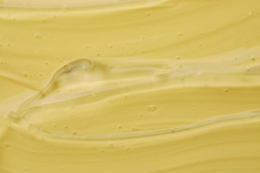 Sarı arkaplanda kozmetik jeli temizle, yakın plan