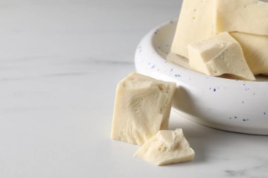 Lezzetli beyaz çikolata parçaları beyaz mermer masanın üzerinde, yakın plan. Metin için boşluk