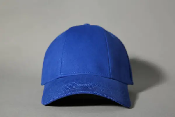 Stylish blue baseball cap on grey background