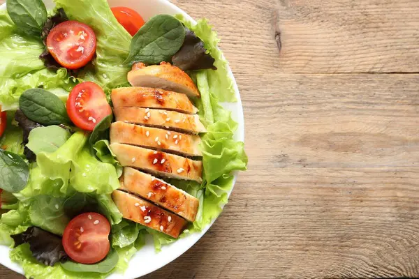 Tavuk, vişneli domates ve ahşap masada ıspanak, harika bir salata. Metin için boşluk