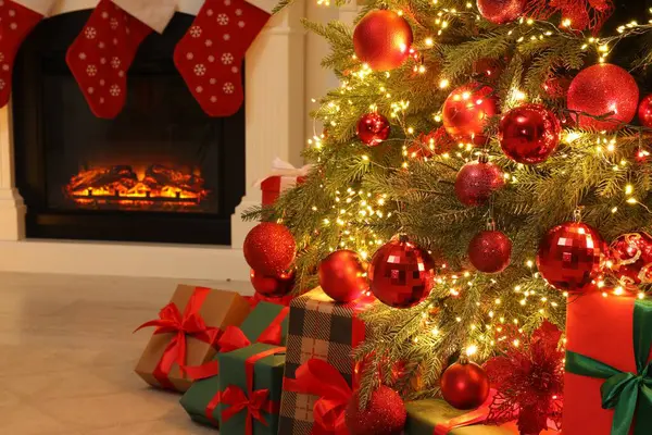 屋内で飾られたクリスマスツリーと暖炉の下の多くのギフトボックス — ストック写真