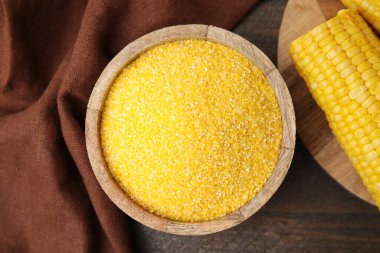 Tabakta çiğ mısır unu ve ahşap masada mısır koçanı.