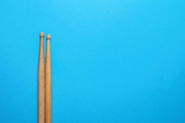 Açık mavi arka planda iki ahşap baget çubuğu, üst manzara. Metin için boşluk