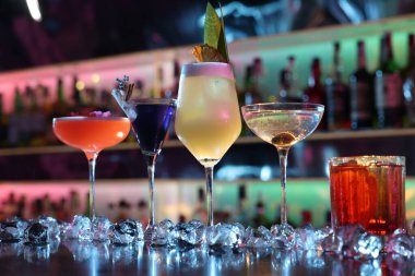 Barda farklı taze alkollü kokteyller ve buz küpleri var.