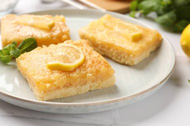 Lezzetli limonlu kekler ve beyaz masada nane şekeri, yakın plan.