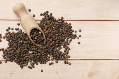 Kepçe ve bir sürü çiğ mercimek açık ahşap masa, üst manzara. Metin için boşluk