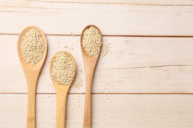 Tahta masada çiğ kinoalı kaşıklar, üst manzara. Metin için boşluk