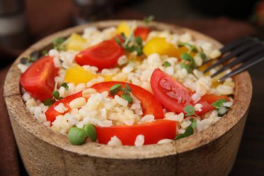 Tabakta sebzelerle pişirilmiş bulgur, yakın plan.