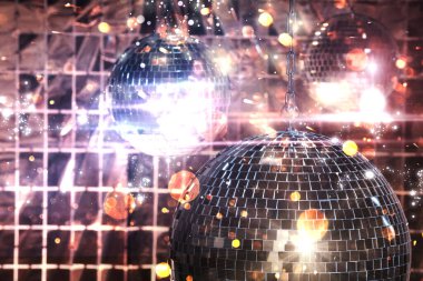 Renkli ışıklar altında folyo parti perdesine karşı parlak disko topları, bokeh etkisi