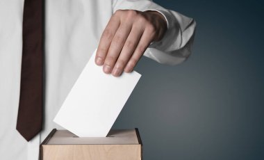 Adam oylarını oy sandığına koyuyor. Renkli arka planda, yakın planda. Metin için alanı olan pankart tasarımı