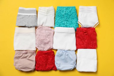 Sarı arka planda katlanmış kadın iç çamaşırları, düz yatış.