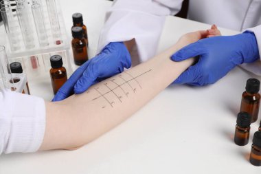 Doktor ışık masasında cilt alerjisi testi yapıyor, yakın plan.