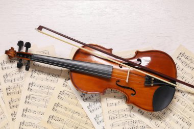 Keman, yay ve müzik kağıtları beyaz ahşap masa, üst manzara