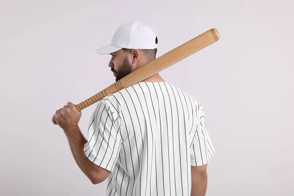Man in stylish baseball cap holding bat on white background, back view