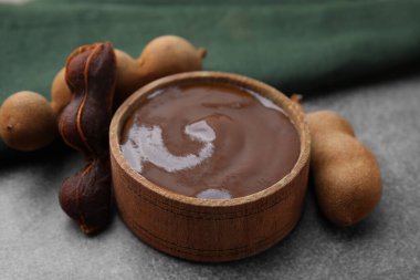 Bir kase demirhindi sosu ve taze kapsüller kahverengi masada, yakın plan.