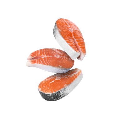 Beyaz arka plana düşen taze somon biftekleri.