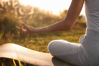 Dışarıdaki yoga minderinde Padmasana egzersizi yapan kadın, yakın plan. Lotus pozu