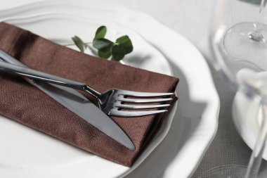 Çatal bıçak takımı ve çiçek dekoru olan güzel bir masa, yakın plan.