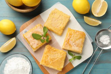 Lezzetli limonlu kekler ve açık mavi ahşap masa üzerinde nane şekeri.