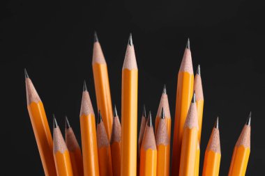 Many graphite pencils on black background, closeup