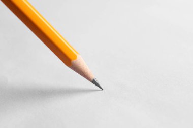 Beyaz arka planda keskin bir grafit kalem, yakın plan. Metin için boşluk