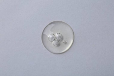 Beyaz arkaplanda kozmetik serumu damlası, makro görünüm,