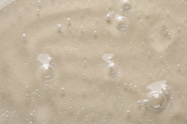 Bej arkaplanda kozmetik serumu temizle, makro görünüm