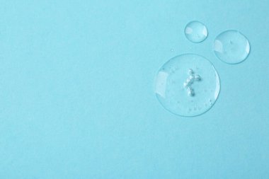 Açık mavi arka planda kozmetik serumu örnekleri, düz. Metin için boşluk