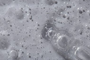 Işıklı arka planda kozmetik serumu olan bir boru, makro görünüm. Metin için boşluk