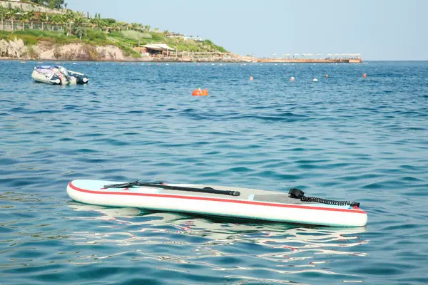 Deniz suyunda kürek çeken bir SUP tahtası.