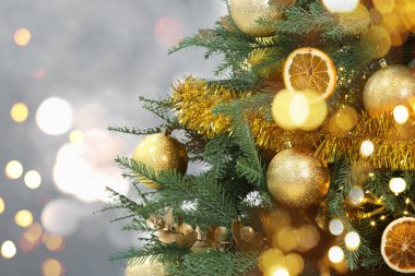 Bulanık arka planda altın şenlik toplarıyla süslenmiş Noel ağacı, bokeh etkisi. Metin için boşluk