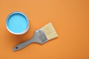 Açık mavi boya ve soluk turuncu arka planda fırça, düz. Metin için boşluk