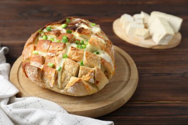 Taze pişmiş ekmek, tofu peyniri ve ahşap masada yeşil soğan. Metin için boşluk