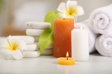 Beyaz masada farklı spa ürünleri ve plumeria çiçekleri olan kompozisyon, yakın plan.