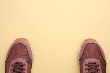 Bej arka planda bir çift şık çocuk ayakkabısı, üst manzara. Metin için boşluk