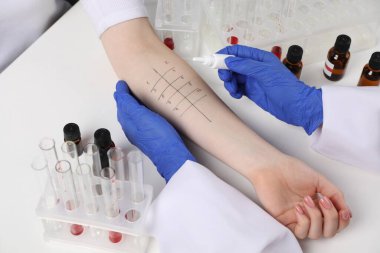 Doktor ışık masasında cilt alerjisi testi yapıyor, yakın plan.