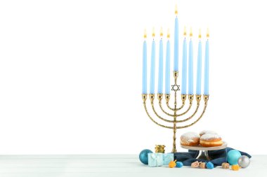 Hanuka kutlaması. Menorah, dreidels ve hediye kutuları ile bembeyaz arka plan karşı kompozisyon