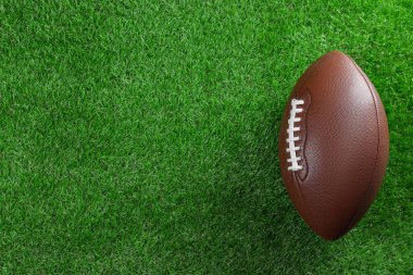 Yeşil çimlerin üzerinde Amerikan futbol topu, üst manzara. Metin için boşluk