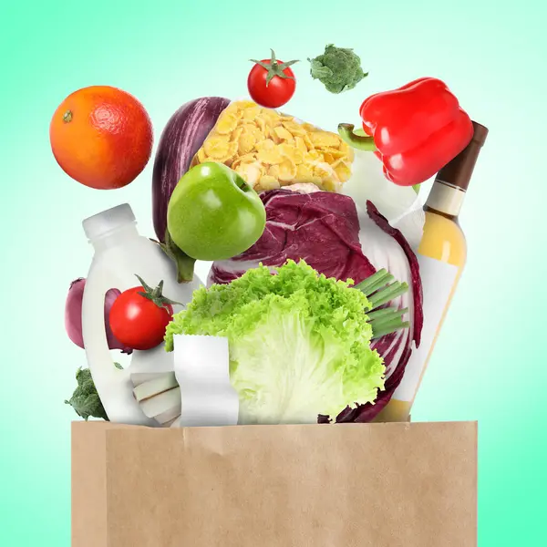 Verschillende Voedingsmiddelen Vallen Papieren Zak Turquoise Achtergrond — Stockfoto