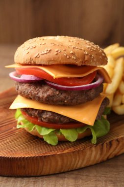 Köfteli lezzetli burger, peynir, sebze ve marul, ahşap masa, yakın plan.