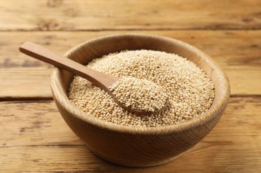 Kuru kinoa tohumları ve kaşık tahta masada, yakın plan.