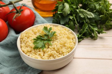 Maydanozlu leziz bulgur ve ahşap masadaki domatesler, yakın plan.