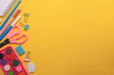 Düz kompozisyonda dizüstü bilgisayar ve diğer okul kağıtları turuncu arka planda, metin için boşluk. Okula geri dön.