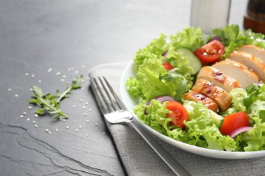 Siyah masada servis edilen tavuk ve sebzeli leziz salata, yakından. Metin için boşluk