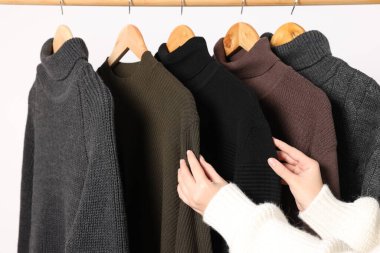 Kadın arka plandan süveteri alıyor, yakın plan.