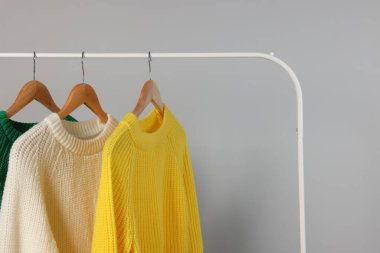 Açık gri arka planda farklı sıcak kazaklar. Metin için boşluk