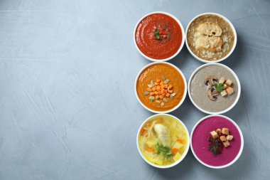 Lezzetli et suyu ve gri masadaki farklı kremalı çorbalar. Metin için boşluk