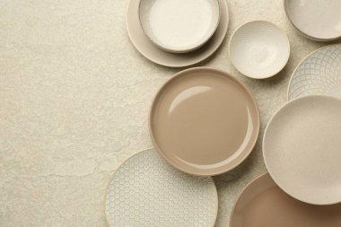 Güzel seramik tabaklar ve kaseler bej masa üzerinde, düz yatıyordu. Metin için boşluk