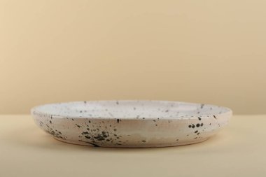 Soluk sarı masada güzel bir seramik tabak, yakın plan. Metin için boşluk