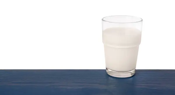 白い背景に対する青い木のテーブルのおいしいミルクの1杯 — ストック写真